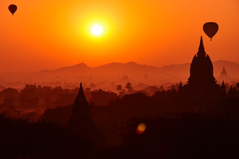 Amazing misty sunrise colors and balloons silhouettes over ancient Pagoda